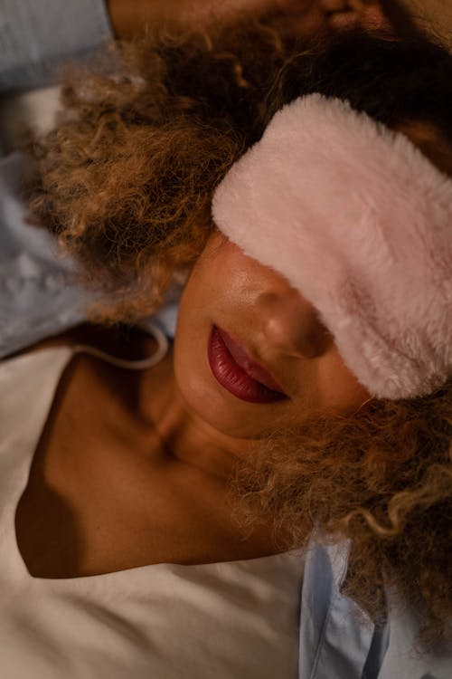 Free Woman Lying Down Wearing a Sleep Mask Stock Photo