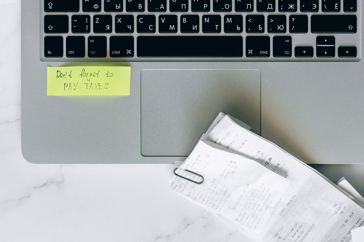 Laptop with tax reminder note and receipts