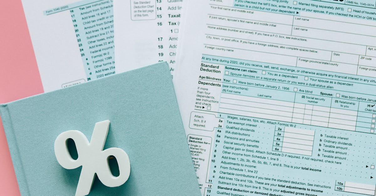 Photo by Nataliya Vaitkevich Tax documents with a percentage symbol on a pink and blue desk setup, emphasizing finance.
