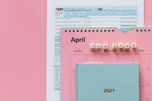 Tax Return Form and 2021 Planner on Pink Surface