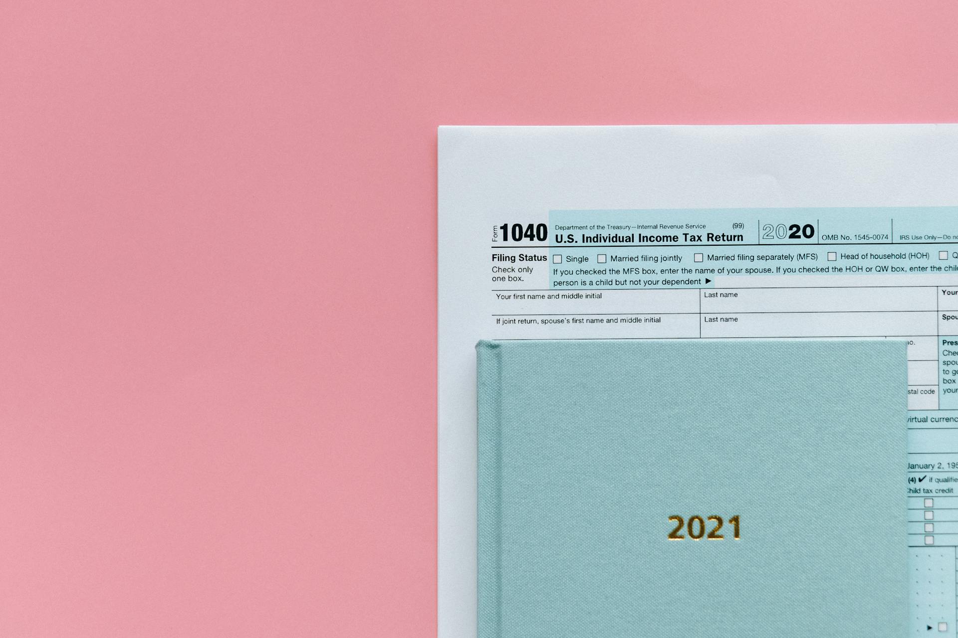 Tax Return Form and 2021 Planner on Pink Surface