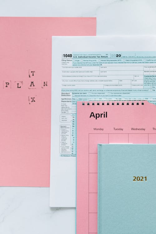 Tax Return Form and 2021 Planner on Pink Surface