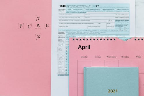 Tax Return Form and 2021 Planner on Pink Surface