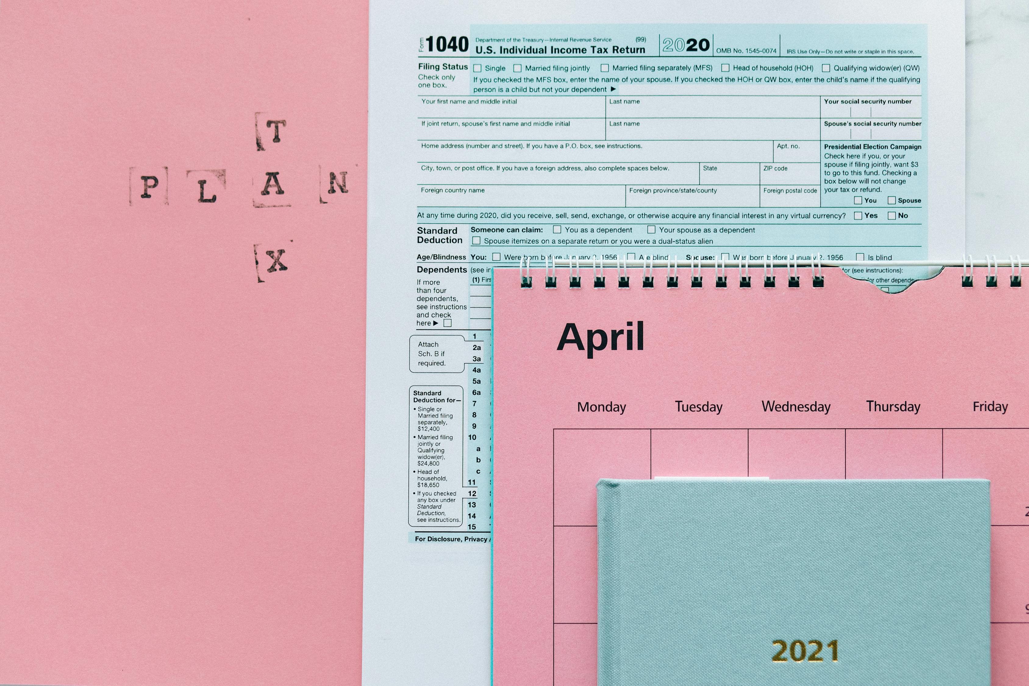Tax Return Form and 2021 Planner on Pink Surface · Free Stock Photo