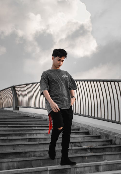 Man in Gray Crew Neck T-shirt and Black Pants Going Down on Gray Concrete Stairs 