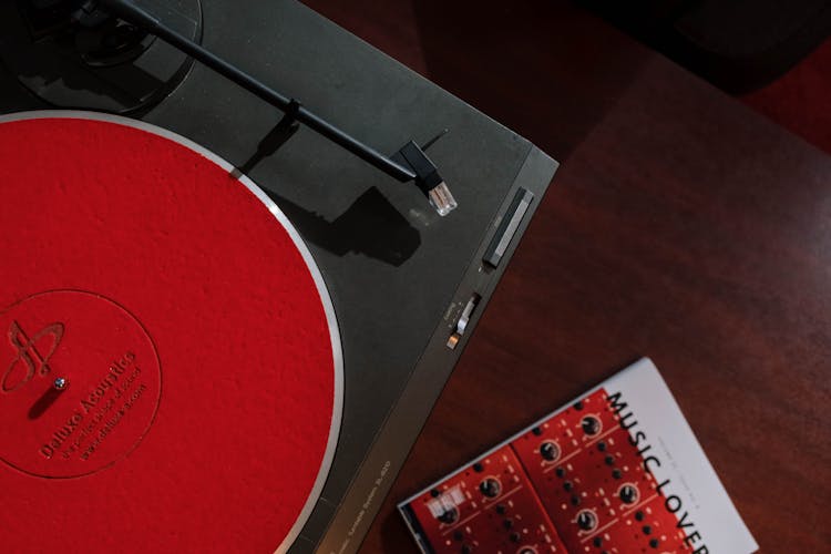 Turntable With Red Slipmat And A Music Magazine On A Table