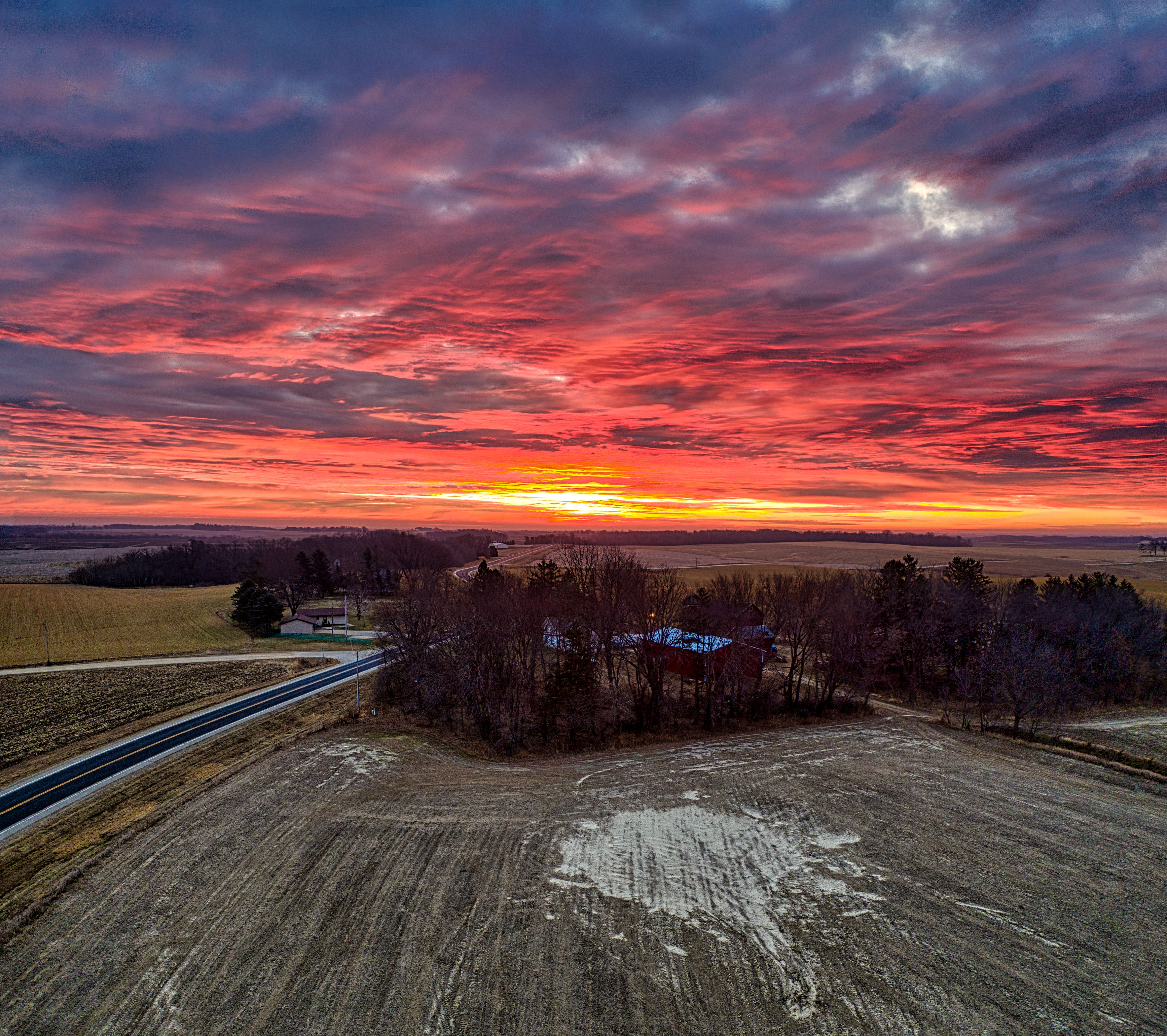 A breathtaking sunset over Minnesota farmland with vivid colors and a serene rural setting.
