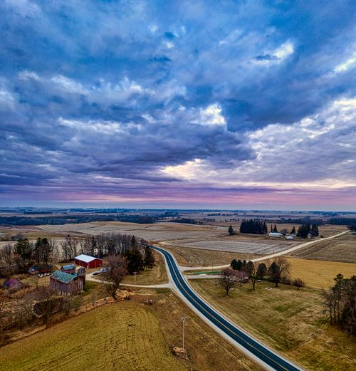 Free Stunning aerial landscape of rural Minnesota at sunset, showcasing fields, winding roads, and farmhouses. Stock Photo