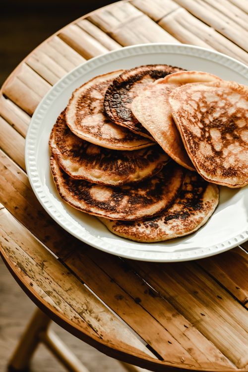 Free A tempting stack of homemade pancakes on a rustic wooden table. Perfect for breakfast inspiration. Stock Photo