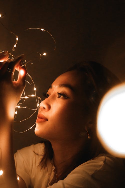 Woman Holding Led Lights and Looking at Them 