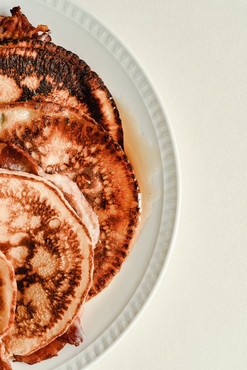 Free Close-up of a plate with perfectly cooked pancakes drizzled with maple syrup. Stock Photo