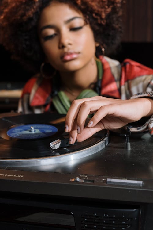 Close-up Photo of Phonograph Player being used by a Woman 