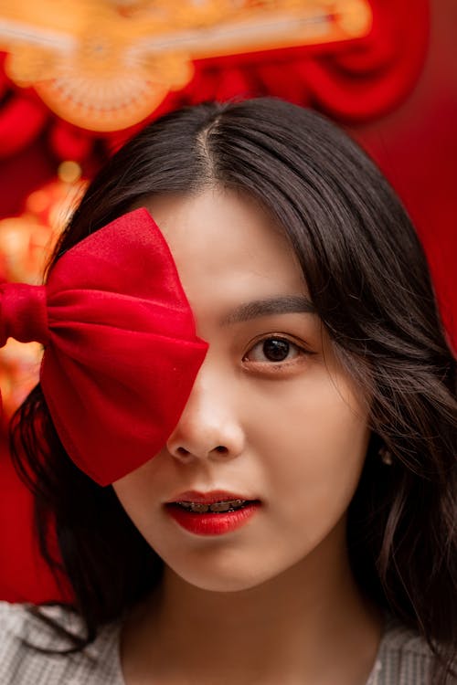 Girl Covering her Face with a Red Bow