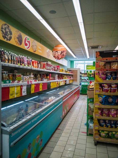 Assorted Food Packs on White Shelves