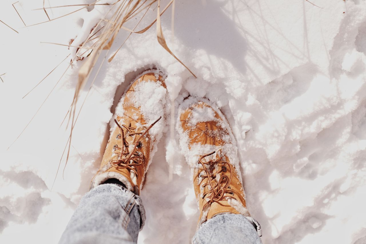 Tan lace-up boots in snow seen from above