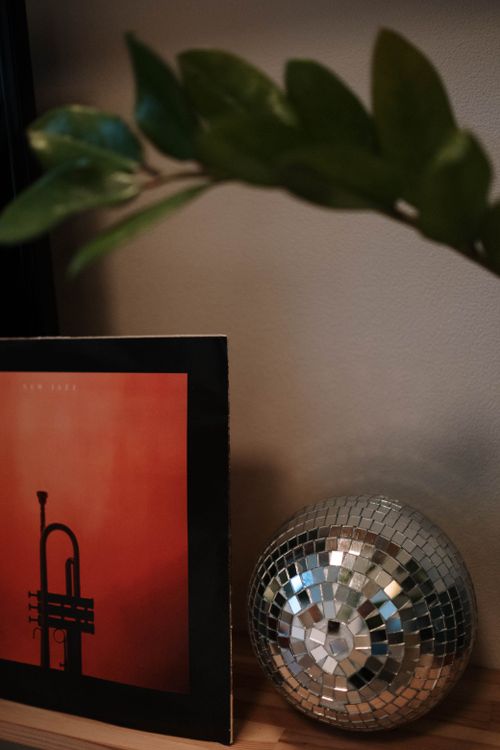 Free A retro still life featuring a vinyl record and a reflective disco ball on display. Stock Photo