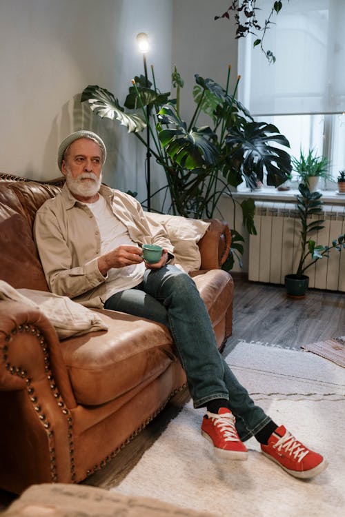 Man Sitting on Brown Leather Couch