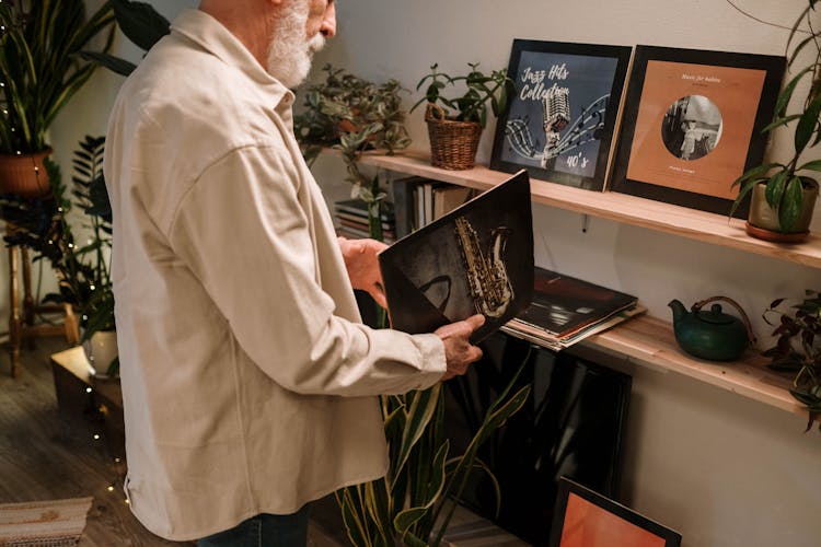 An Elderly Man Holding A Vinyl Record