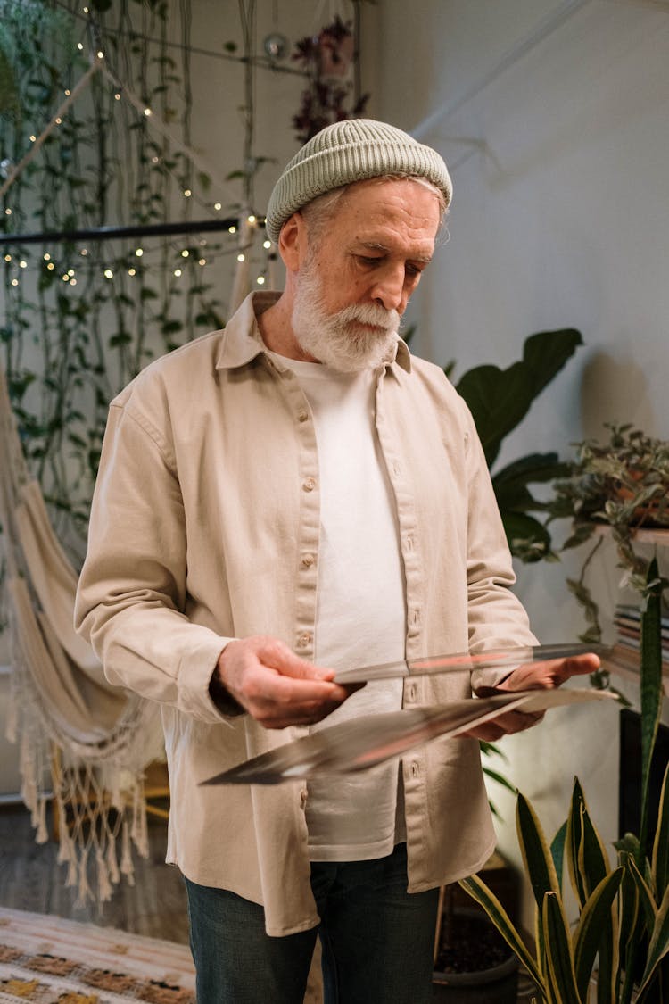 An Elderly Man Holding A Vinyl Record