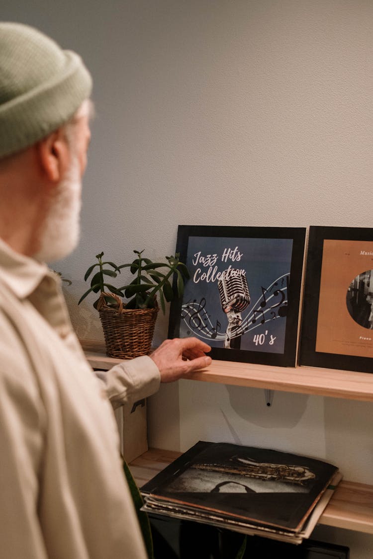 
A Bearded Elderly Man Looking At Framed Vinyl Records