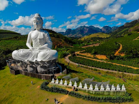 Stunning aerial shot of the Giant Buddha statue in Ibiraçu, Brazil, against a scenic landscape.
