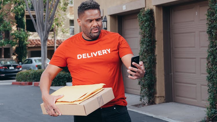 A Deliveryman Carrying Package And Mails Looking Lost And Confused