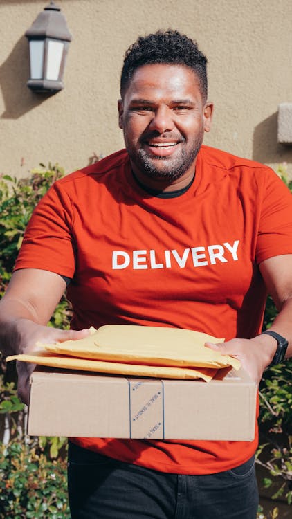 Smiling Man in Red Crew Neck T-shirt Making a Delivery · Free Stock Photo