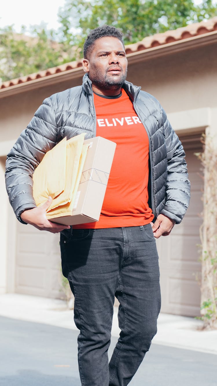 Man In Gray Jacket Carrying A Package And Mails For Delivery