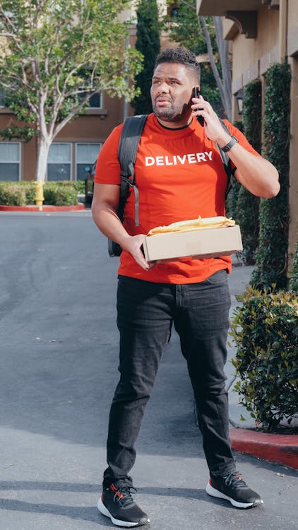 A Deliveryman Carrying a Package Feeling Confused and Lost · Free Stock ...