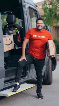 A cheerful delivery man holding parcels next to his van during a workday.