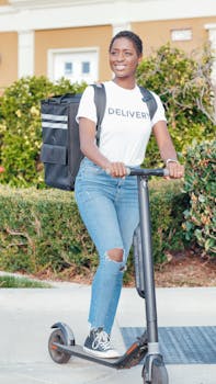 Smiling woman delivering on e-scooter with delivery bag outdoors.