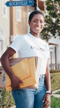 Cheerful delivery woman holding packages on a sunlit neighborhood street.