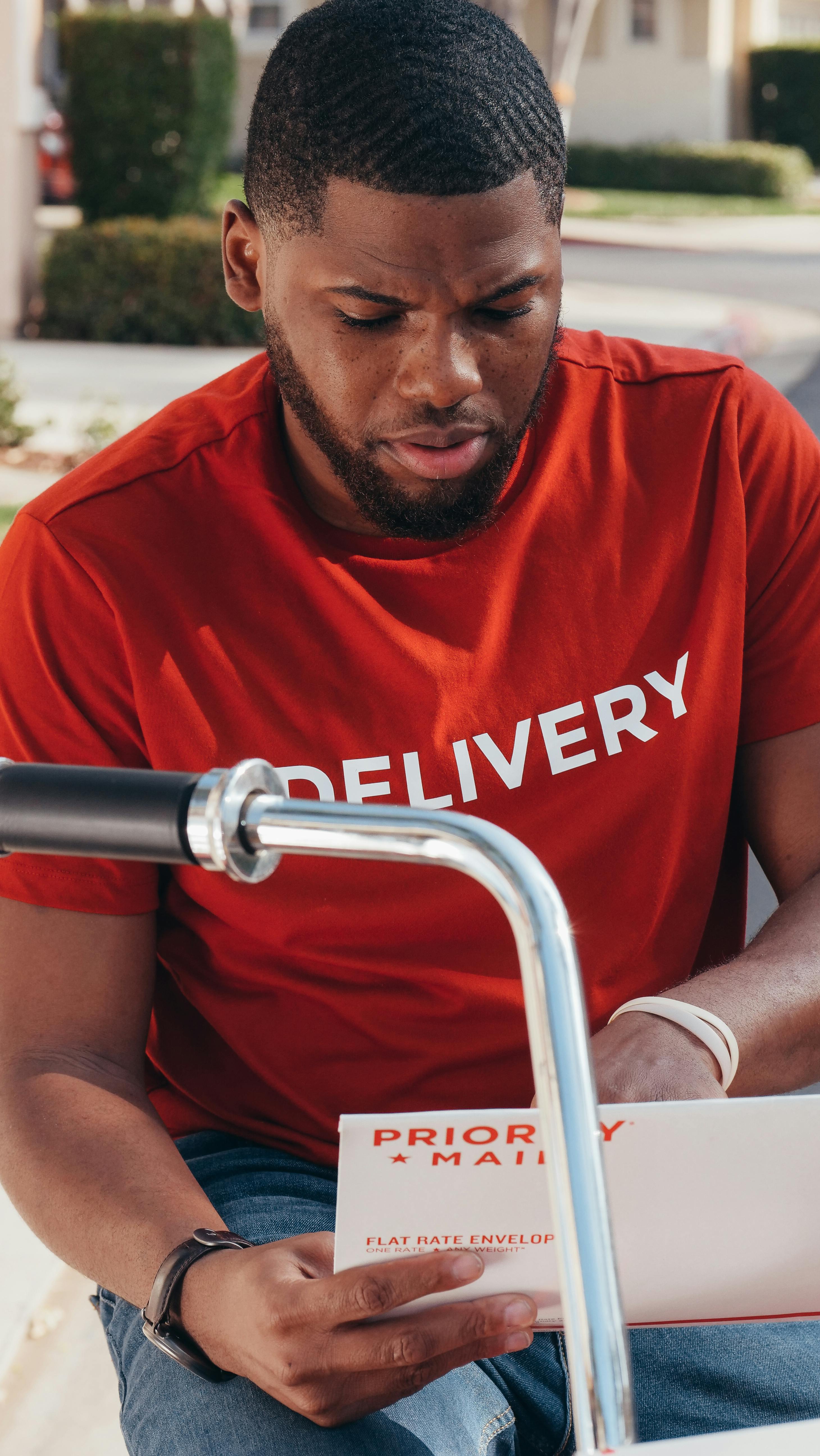 man in red and white nike crew neck t shirt sitting on stainless steel chair