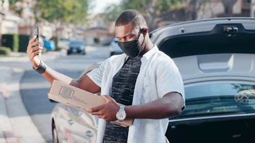 Free Man in White Shirt Holding a Brown Box Stock Photo