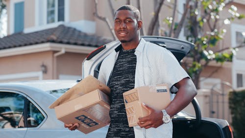 Free Man in White Button Up Shirt Delivering Packages Stock Photo