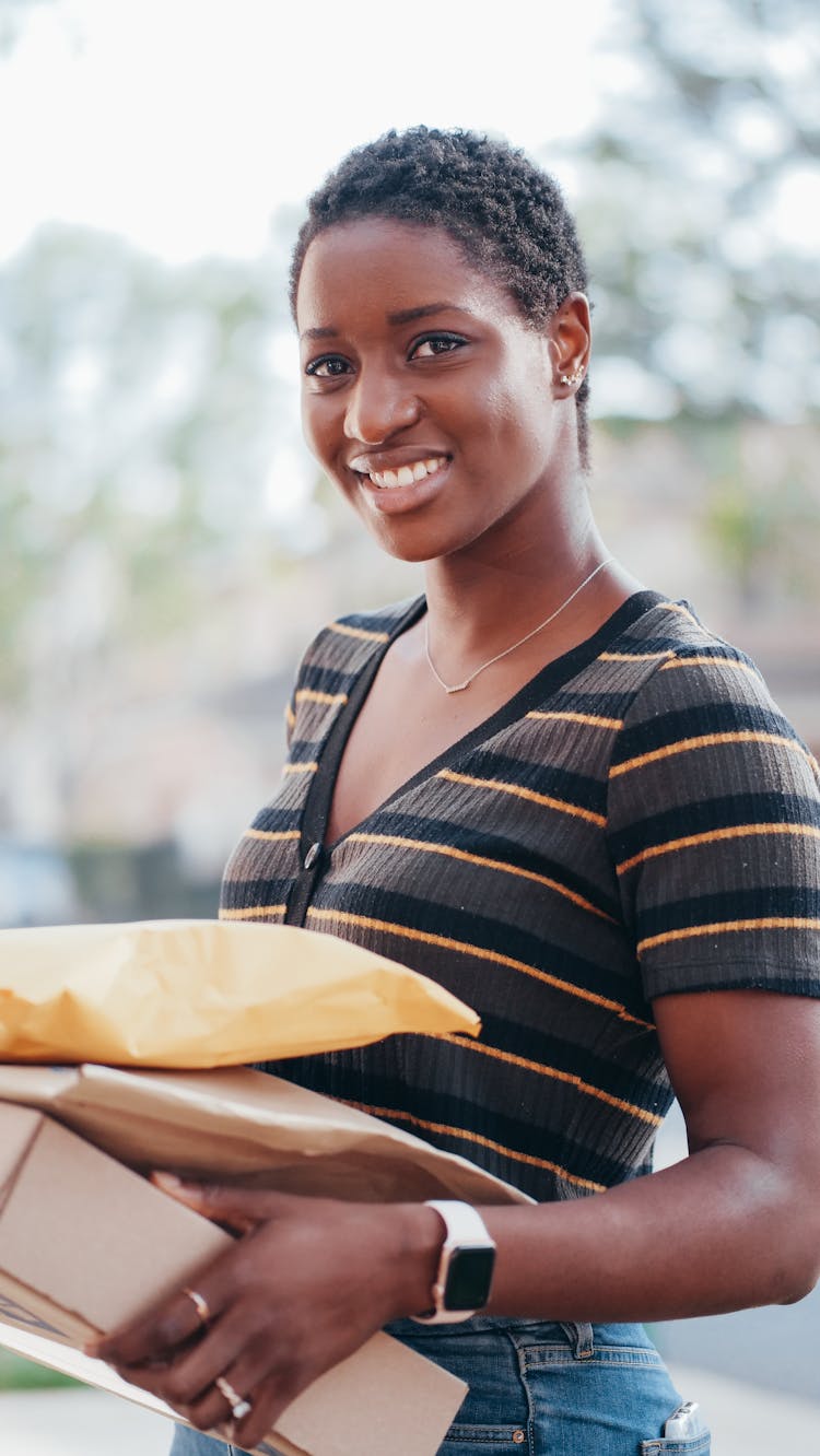 Woman In Black And Brown Shirt Carrying Brown Box