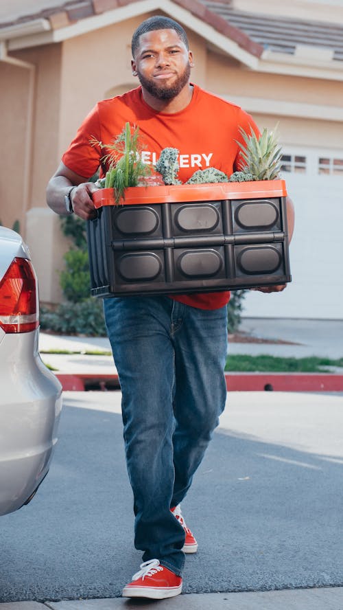 Man Carrying a Plastic Crate