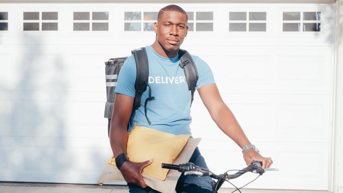 Bicycle courier holding parcels while preparing for delivery