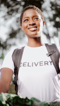 Portrait of a cheerful delivery woman in uniform, representing service and efficiency.