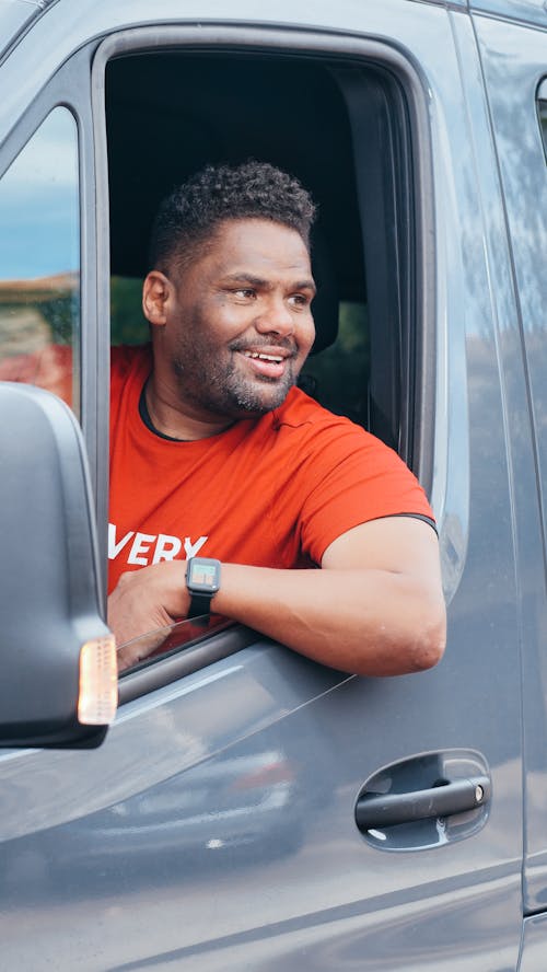 Man in Red Crew Neck T-shirt Sitting in a Van