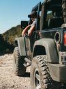 Man in Black Jacket Driving a Black Jeep Wrangler
