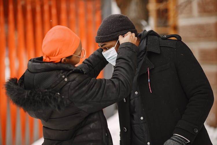 Woman Putting Facemask On A Man