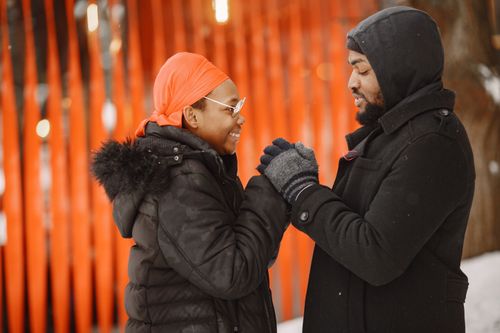 Free Warmly dressed couple share a joyful moment outdoors in winter. Stock Photo