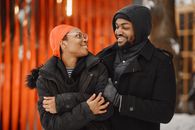 Man in Black Winter Jacket Keeping a Woman Warm
