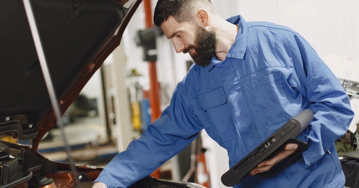 A technician working on an electric vehicle, using new diagnostic equipment.