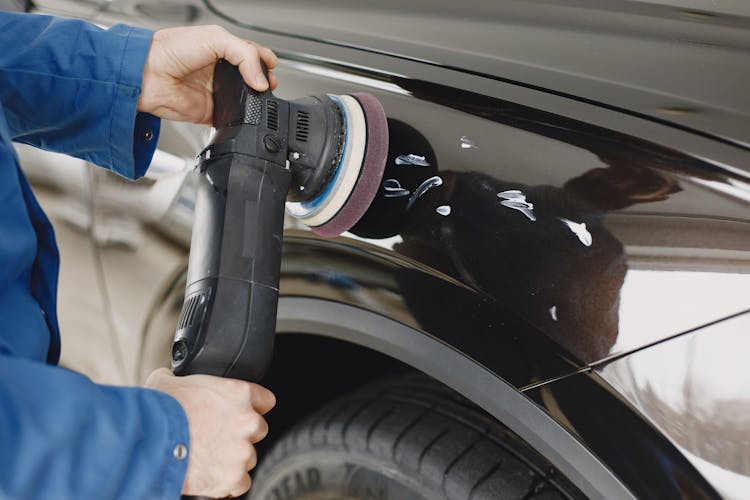 A Person Buffing A Car