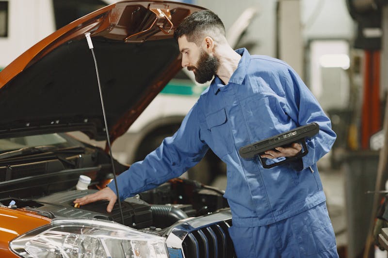 Automotive technician working under the hood of a vehicle