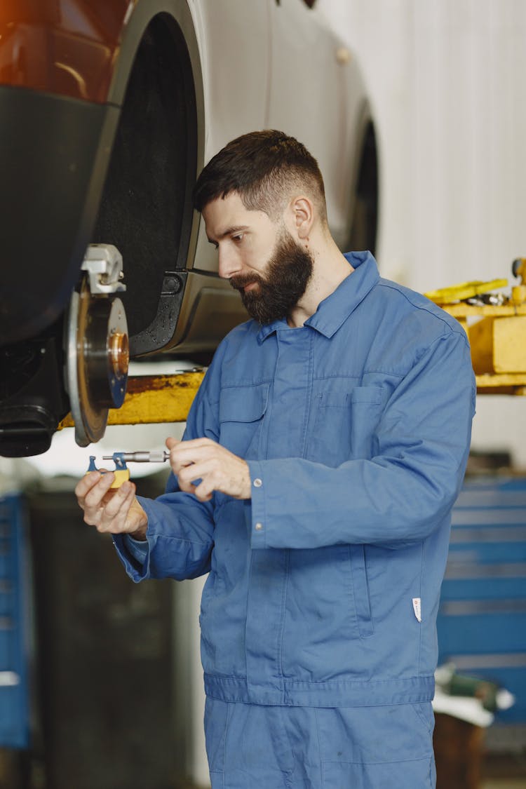 A Man Fixing The Car Brakes