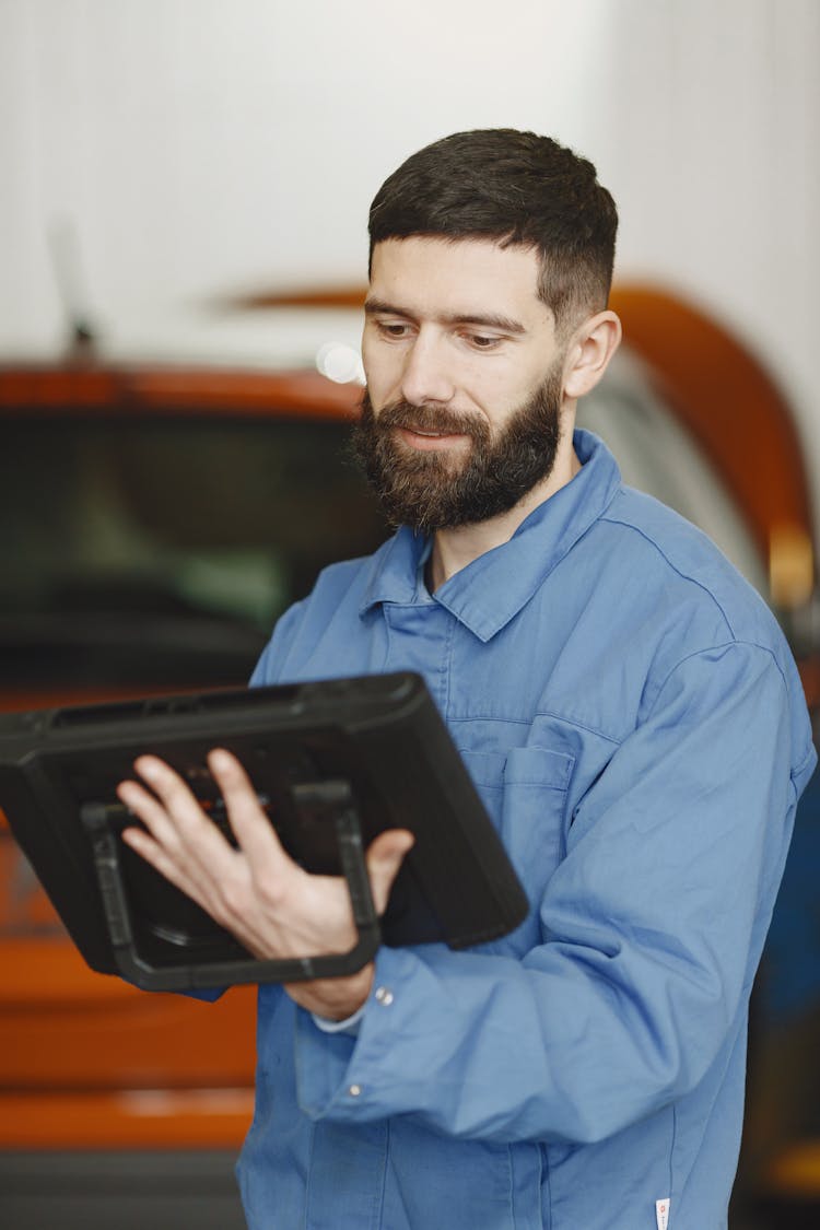 Bearded Mechanic Holding A Tablet 