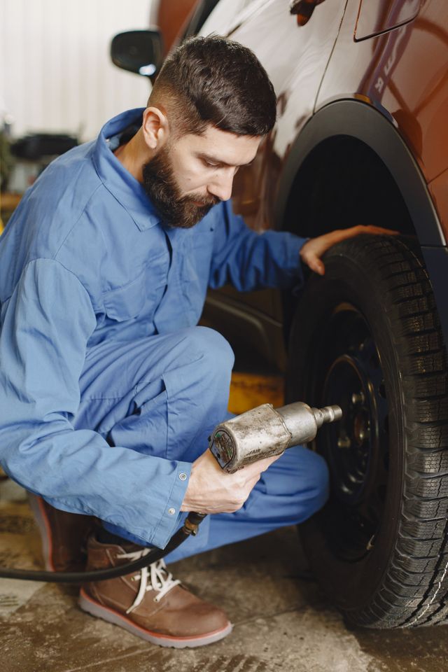 Portrait of Imran Khan servicing a car tire